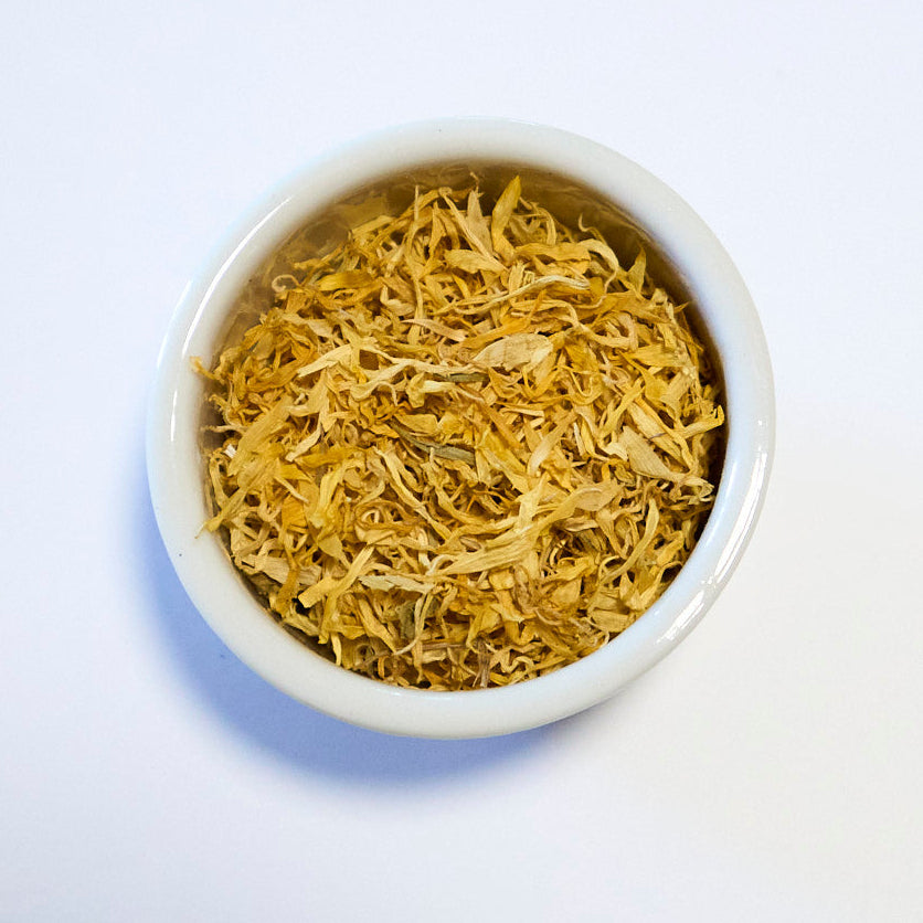 White bowl filled with dried herbs on a white background