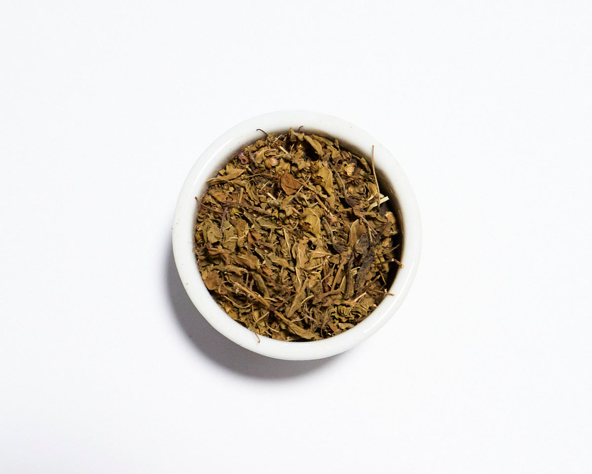 white bowl holding holy basil tea with white background