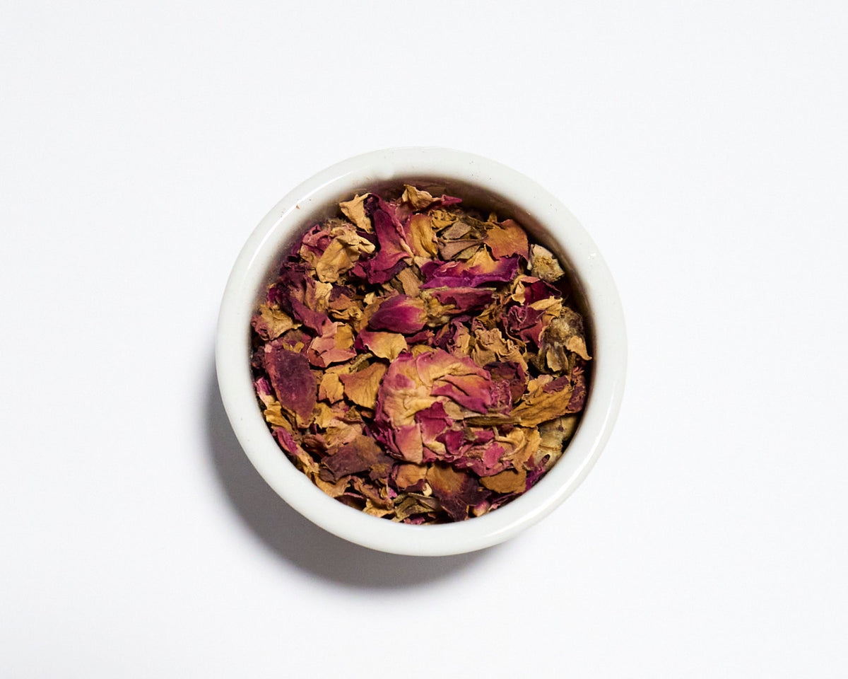 white bowl with dried rose petals and white background
