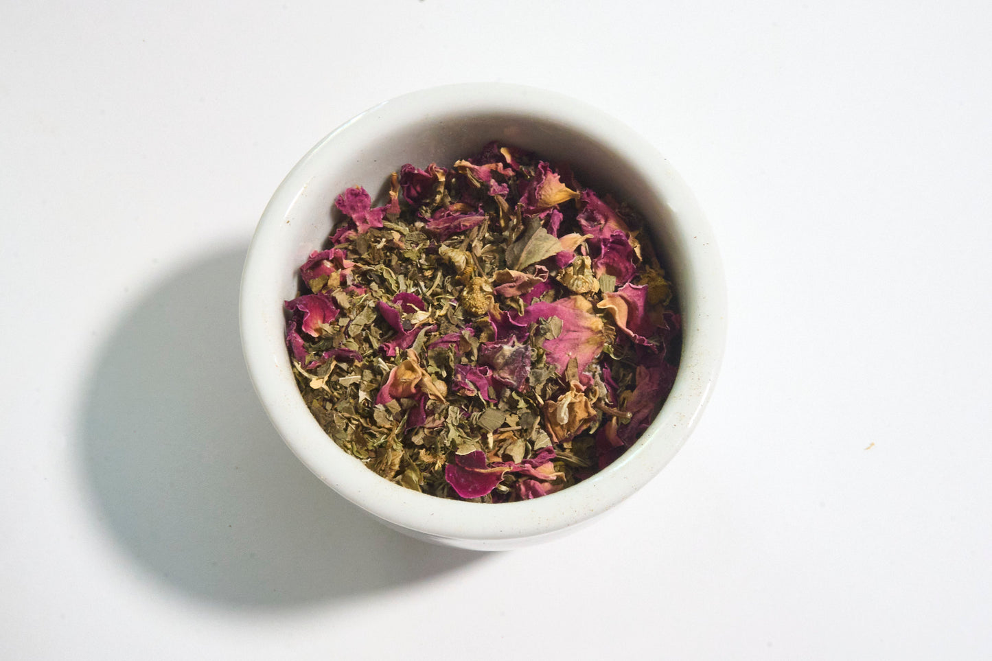 white bowl filled with calming Ayurvedic tea Solace with rose petals chamomile lemon balm holy basil