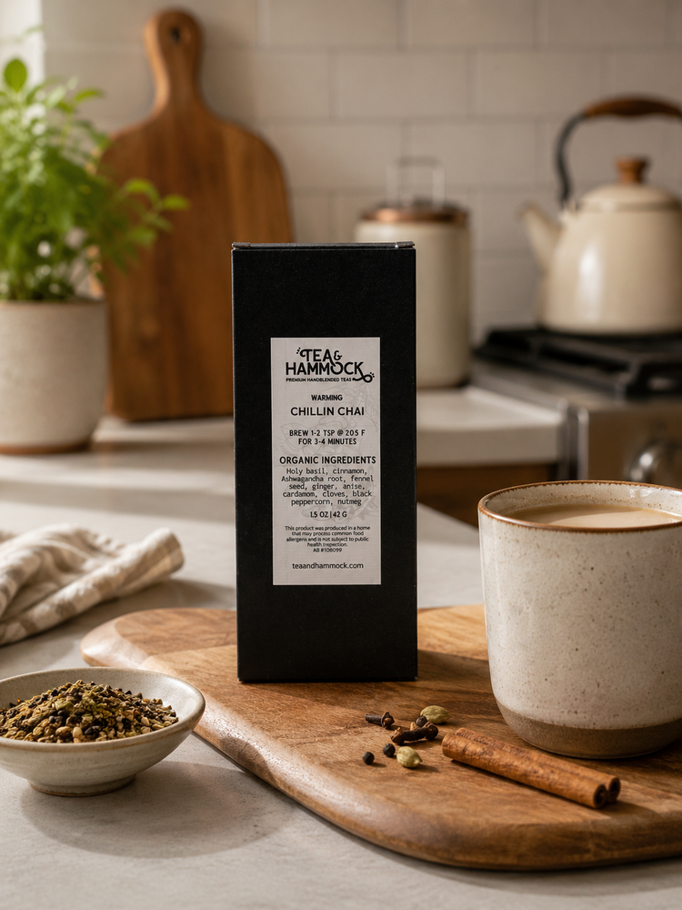 chillin chai from tea & hammock sits on a wooden cutting board in a kitchen next to a beautiful tea mug holding tea