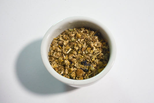 White bowl filled with dried herbs on a white background