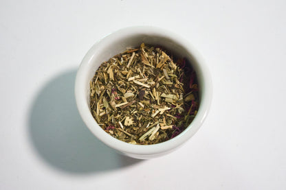 White bowl filled with dried herbs on a white background