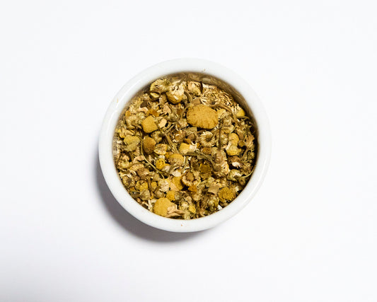white bowl containing chamomile tea with white background
