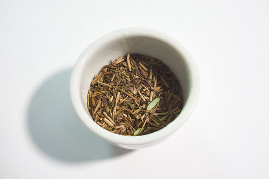 White bowl filled with dried herbs on a light background