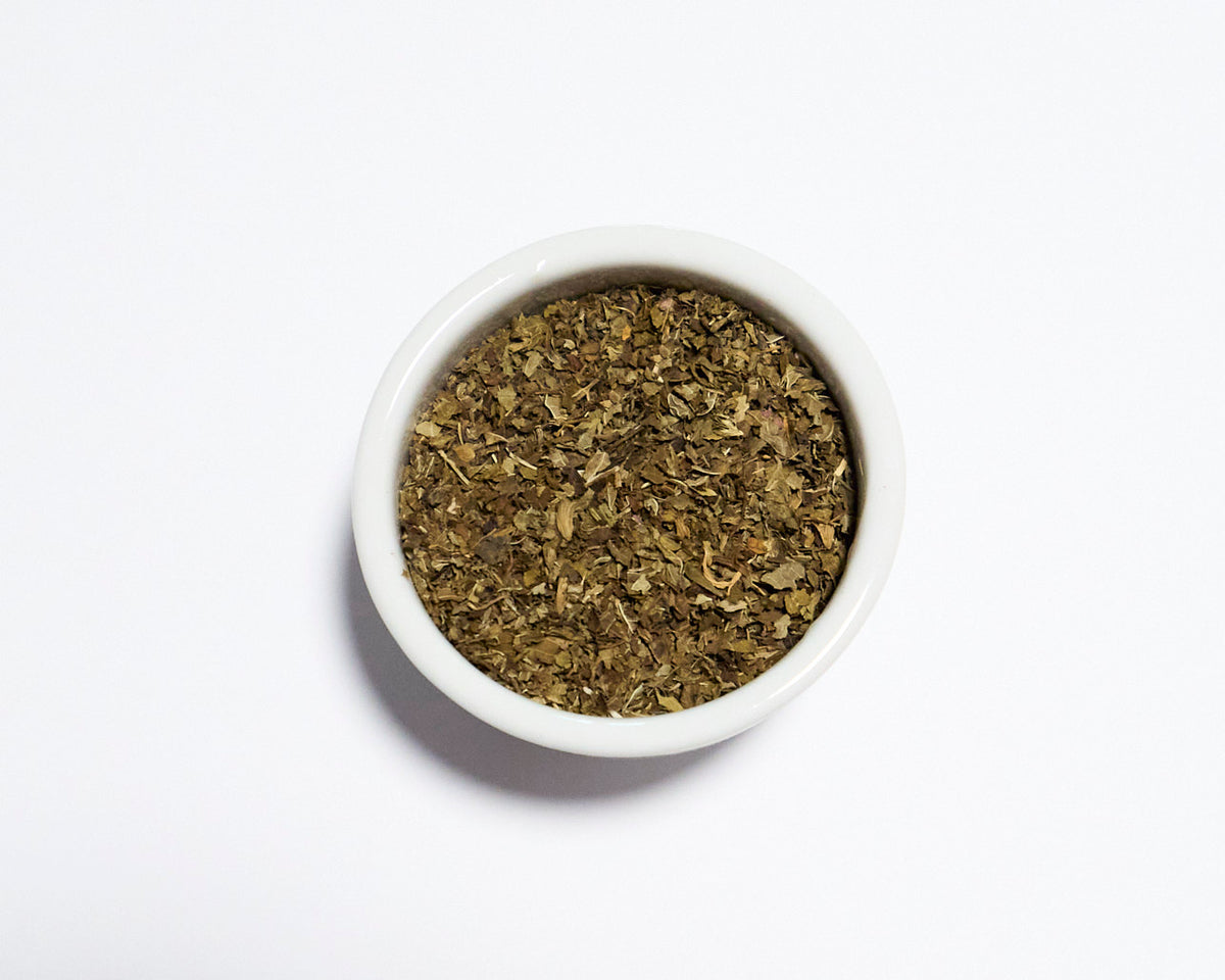 white bowl holding lemon balm tea with white background