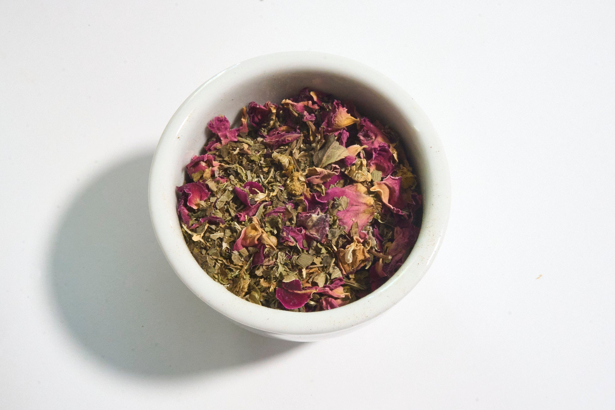 white bowl filled with calming Ayurvedic tea Solace with rose petals chamomile lemon balm holy basil